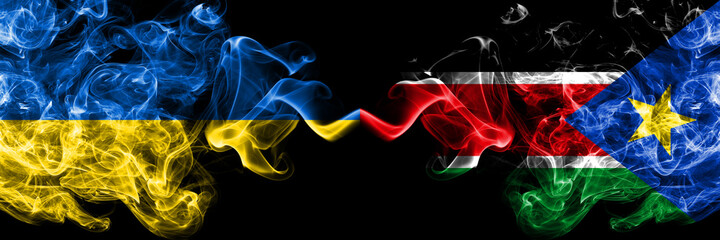 Ukraine, Ukrainian vs South Sudan smoky mystic flags placed side by side. Thick colored silky abstract smokes flags.
