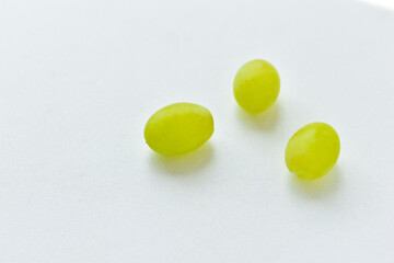 Three grapes close up on a white background