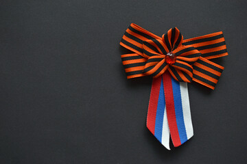 St. George ribbon and Russian flag in a ribbon on clothes on a black background