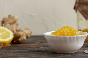 Lemon ginger jam in a cup on a wooden background, Antiviral product, Herbal medicine, Healthy food, selective focus