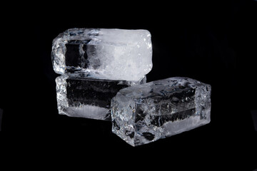 Large melting cube of clear ice on black background,Translucent ice block