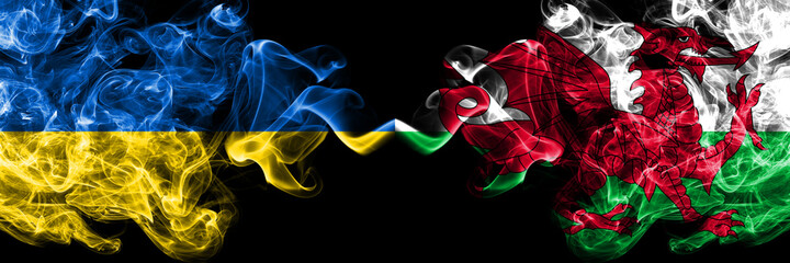 Ukraine, Ukrainian vs Wales, United Kingdom smoky mystic flags placed side by side. Thick colored silky abstract smokes flags.