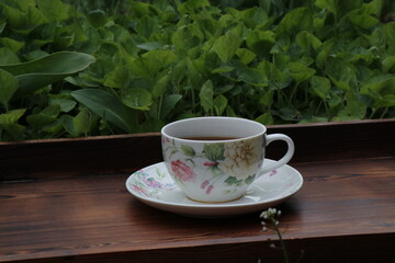 A cup of tea and spring flowers. Flower tea on a wooden tray. Tea drinking in the spring.
