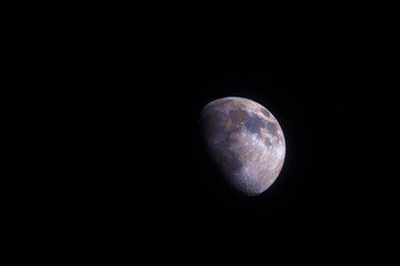 Moon two thirds 66%  phase photographed through a long focal telescope. Scientific colored for better understanding of minerals and surface geology - each color represents different material.