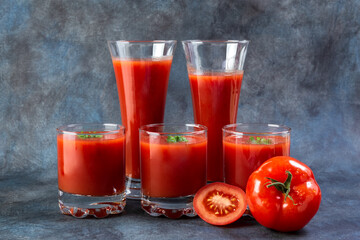 Tomato juice. Tomatoes in a basket and tomato juice in glasses.