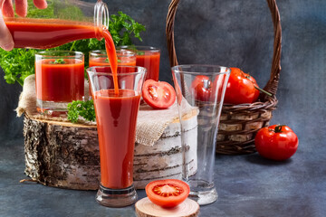 Tomato juice. A hand pours tomato juice into a glass.