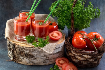 Tomato juice. Tomatoes in a basket and tomato juice in glasses.