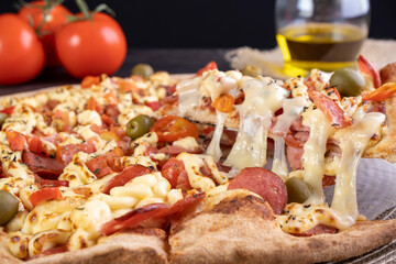 pizza covered with tomato sauce, catupiry cheese, sliced pepperoni, diced tomato and chili pepper