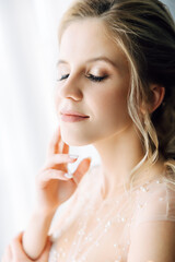 Stylish luxury gorgeous european bride posing on the background hotel room. Close up portrait with blurred background.