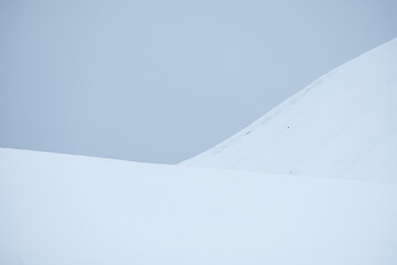 snowy mountain with contrasting sky and detail on the slope