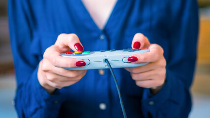 Woman using retro gaming console controller. Gaming, hobby, technology and leisure time concept