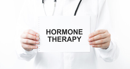 Female doctor holding a notebook with the name of the diagnosis hormone therapy. Medical concept.
