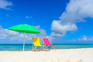 Colorful beach lounge chairs and umbrella at the beach