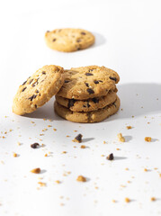 Chocolate chip cookies and crumbs on white background