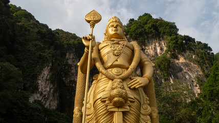 The Batu Caves Lord Murugan Statue and entrance near Kuala Lumpur Malaysia. A limestone outcrop located just north of Kuala Lumpur, Batu Caves has three main caves featuring temples and Hindu shrines.