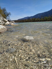 Wellen spiegeln im Sonnenlicht am Flussufer