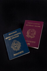Italian and Uruguayan passport in background black