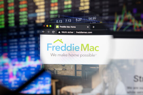 Freddie Mac company logo on a website with blurry stock market developments in the background, seen on a computer screen through a magnifying glass