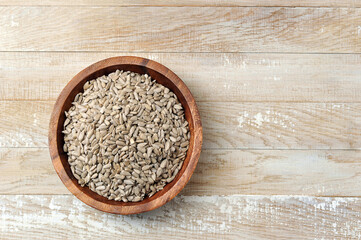 peeled sunflower seeds in a wooden bowl