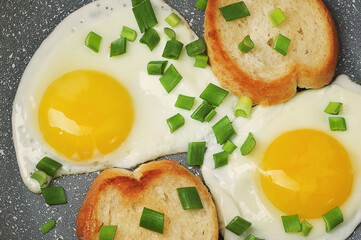 breakfast with fried eggs and green onions and baguette