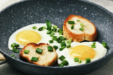 Fototapeta na wymiar breakfast with fried eggs and green onions and baguette