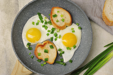 breakfast with fried eggs and green onions and baguette