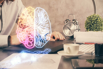 Double exposure of man's hand holding and using a digital device and brain hologram drawing. Data concept.