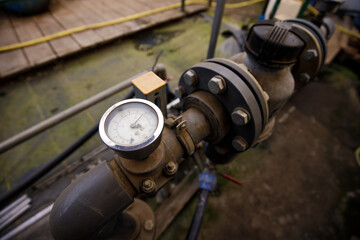 Close up of water pressure sensor or manometer with pipes and valves. Industrial concept