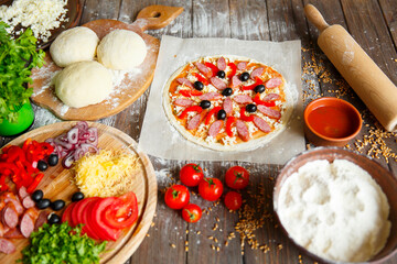 Cook in the kitchen putting the ingredients on the pizza. Pizza concept. Production and delivery of food