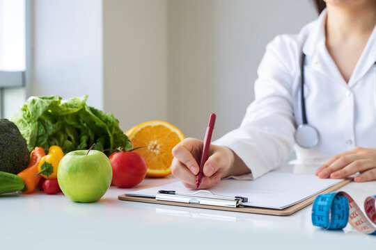 Nutritionist doctor writing diet plan in office