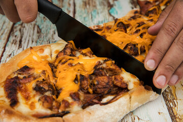 Gastronomy. Rustic flavors. Closeup view of a male caucasian chef slicing a cheddar, mozzarella...
