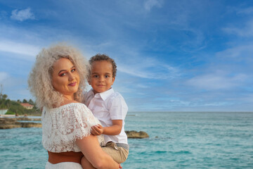 A caucasian mother and mixed race son enjoying a day out at the beach.