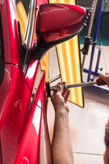 The technician removes dents on the car using the method without painting. PDR. Car body repair. - obrazy, fototapety, plakaty