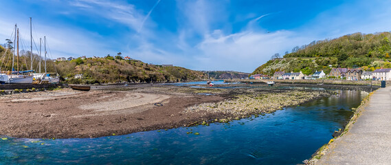A view across the harbour at low tide at Lower Fishguard, South Wales on a sunny day