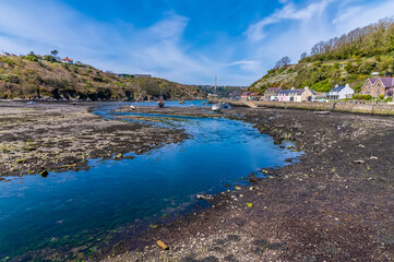A view along the River Gwaun a low tide in the harbour at Lower Fishguard, South Wales on a sunny day