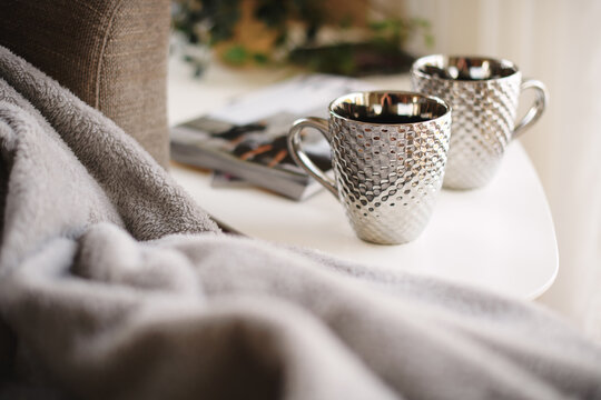 Silver mugs and fluffy, warm blanket