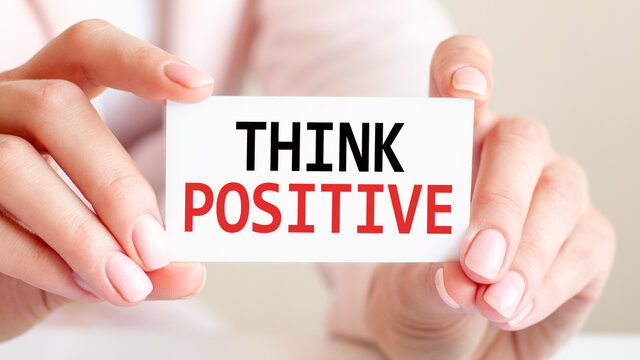 think positive written on a card in woman hands