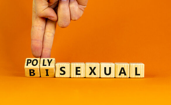 Bisexual or polysexual symbol. Doctor turns wooden cubes and changes the word 'polysexual' to 'bisexual'. Beautiful orange background, copy space. Social, bisexual or polysexual concept.