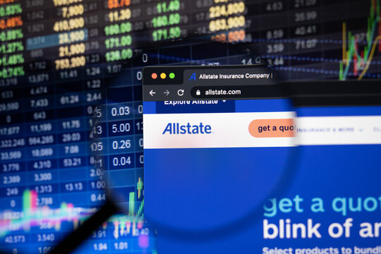 Allstate company logo on a website with blurry stock market developments in the background, seen on a computer screen through a magnifying glass