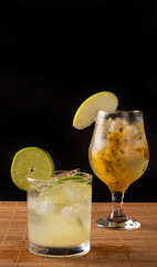 Brazilian drink, Sake caipirinha with passion fruit and sake caipirinha with lemon on a wooden mat,...