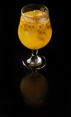 Brazilian Drink, Sake caipirinha with passion fruit in a bowl, on a reflective black surface, black background, selective focus.