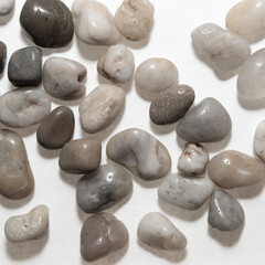 decorative stones, or smooth polished natural pebbles (some quartz crystal) on white - square format