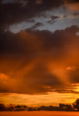 Dramatically illuminated clouds at sunset with cross in the middle