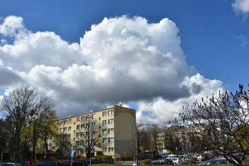 Fototapeta na wymiar chmuryna wiosnę nad domami w mieście, Polska