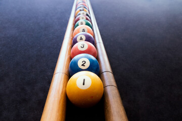 Colored billiard balls arranged in numerical order on the billiard table. Focus selective.