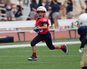 Young athletic boy playing in a youth tackle football game © Joe