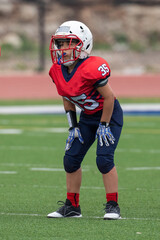 Young athletic boy playing in a youth tackle football game