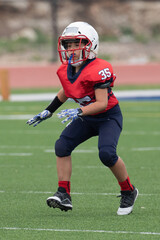 Young athletic boy playing in a youth tackle football game