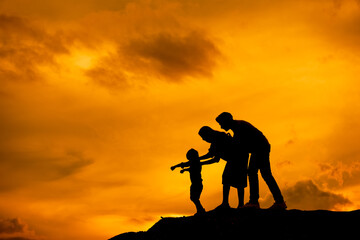 silhouette of happy family father mother and son playing outdoors at sunset.