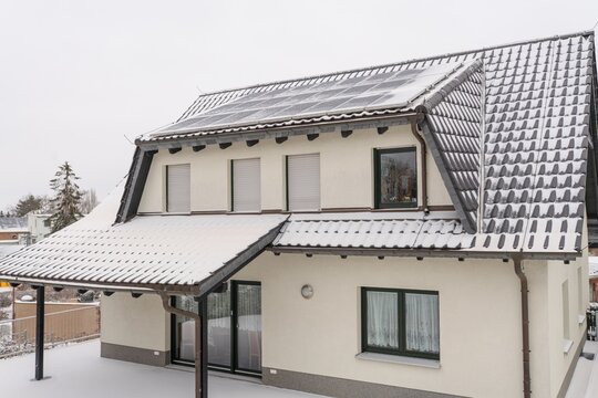 Einfamilienhaus mit Photovolthaik im Winter bei Schnee